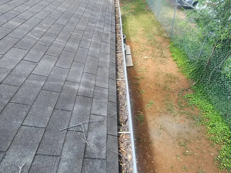 Gutter run packed solid with leaves and shingle grit in Moneta, VA