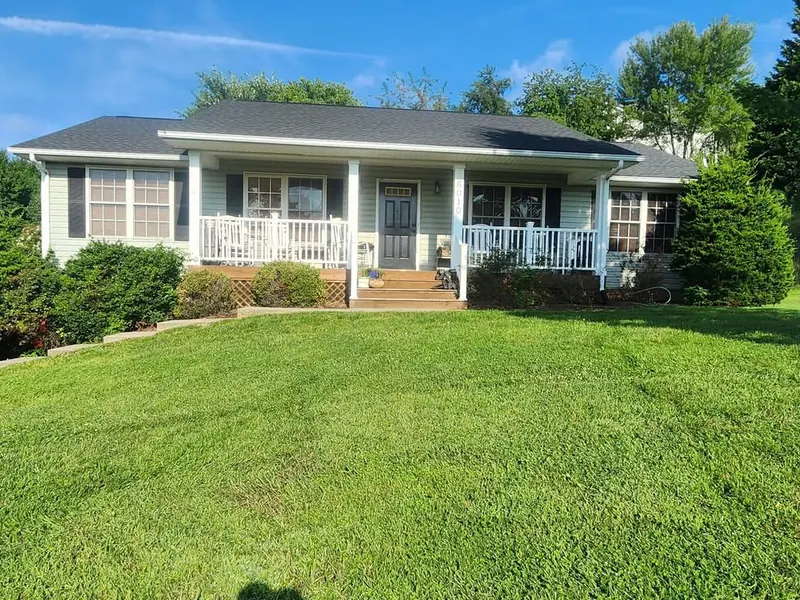 Foundation beds full of overgrown shrubs before tear-out in Roanoke, VA