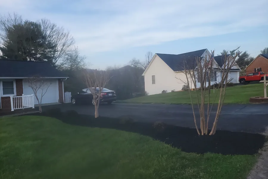 Fresh mulch bed edged along the driveway with crepe myrtles trimmed back in Vinton, VA